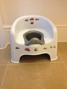 A potty seat with cars on it for a white attempt at potty training.