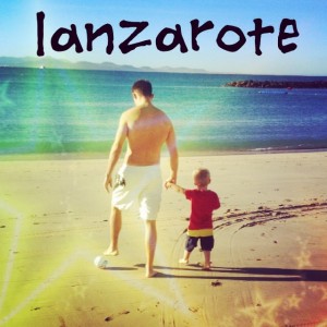 A man and a child walking on the beach in Lanzarote.