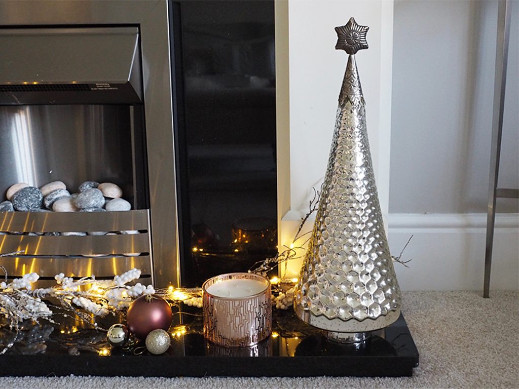 A fireplace with Christmas decorations lit up on it