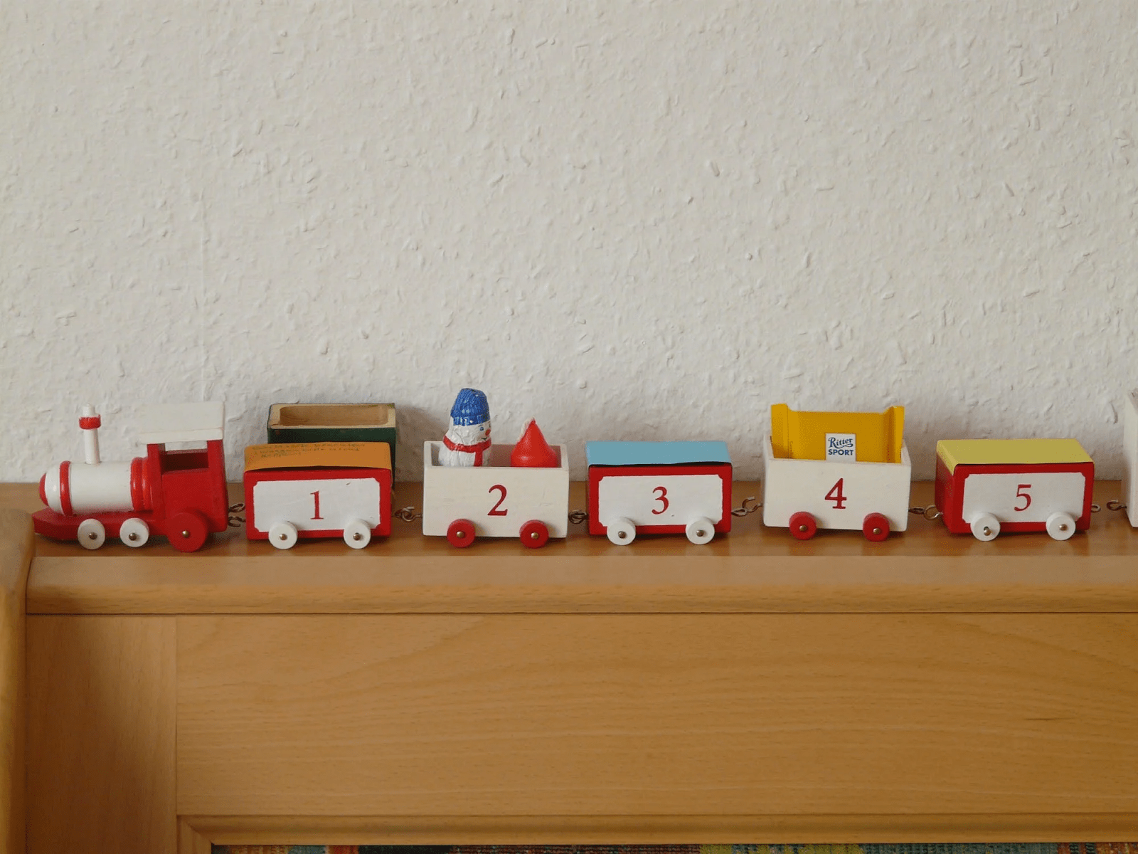 A colourful wooden train. Each carriage has a number painted on it from 1 to 5