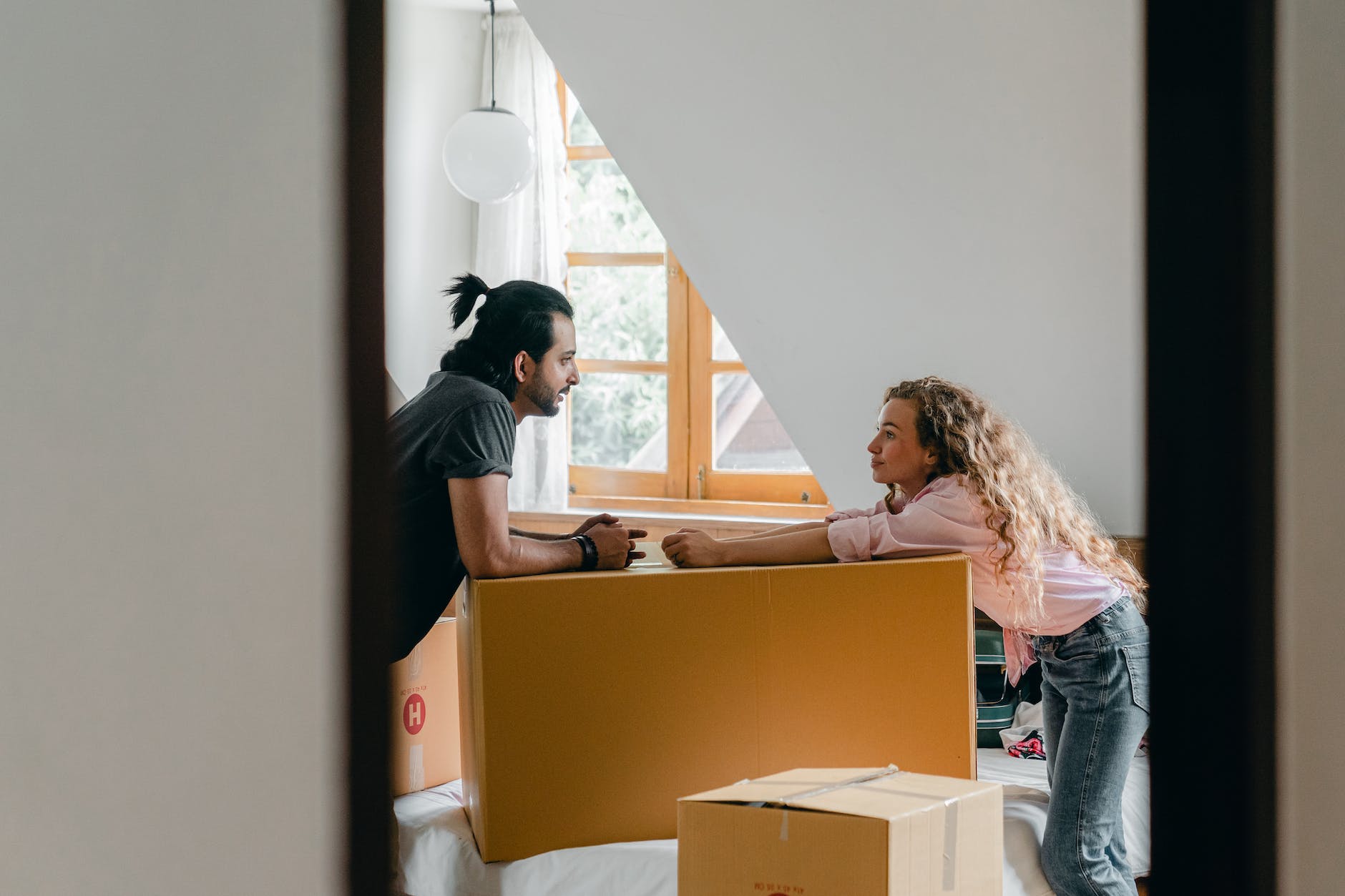 happy diverse couple opening cardboard boxes in new home