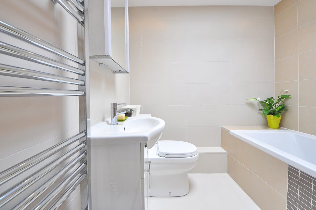 A neutral coloured bathroom. The walls are an off white or beige sort of colour with a white bathroom suite.