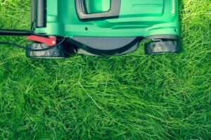 An Auto Draft lawn mower is laying on the grass.