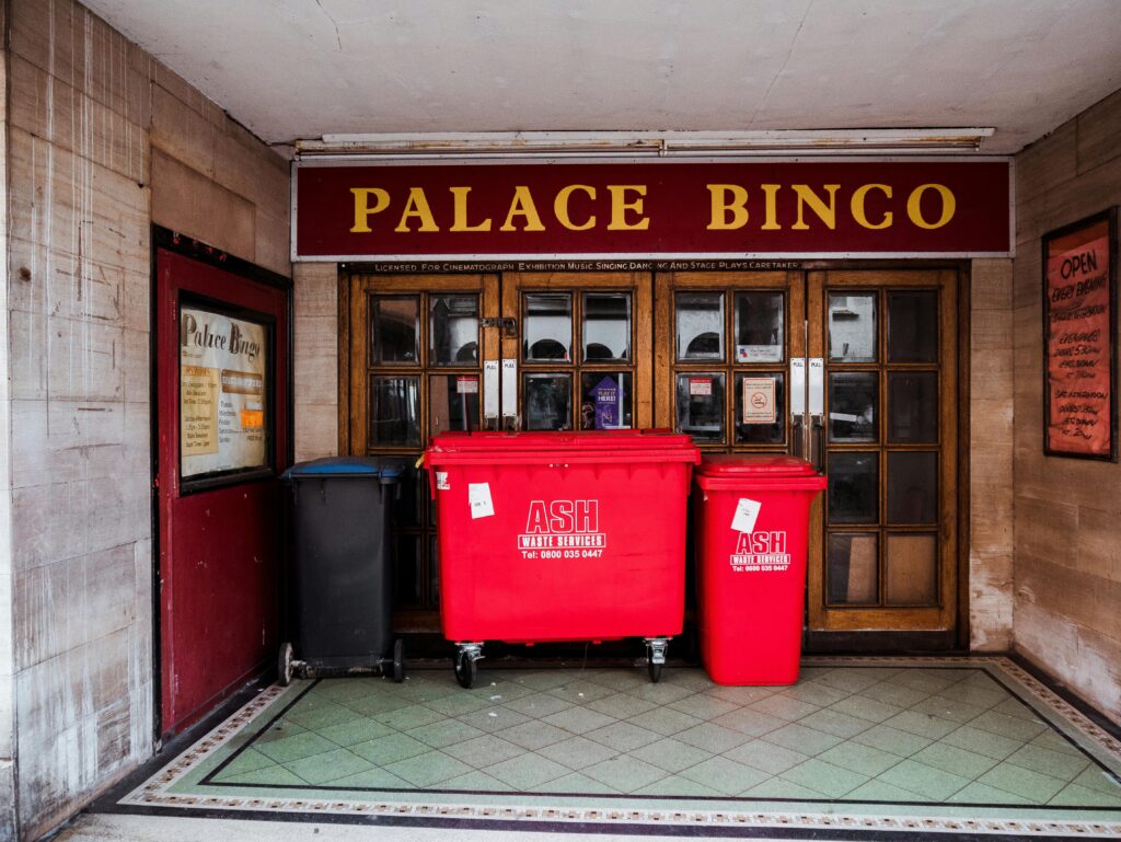 Red trash cans in front of a building providing waste service.