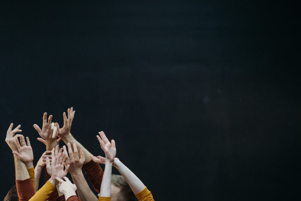 A group of dancers showcasing their talent with hands raised high in the air.