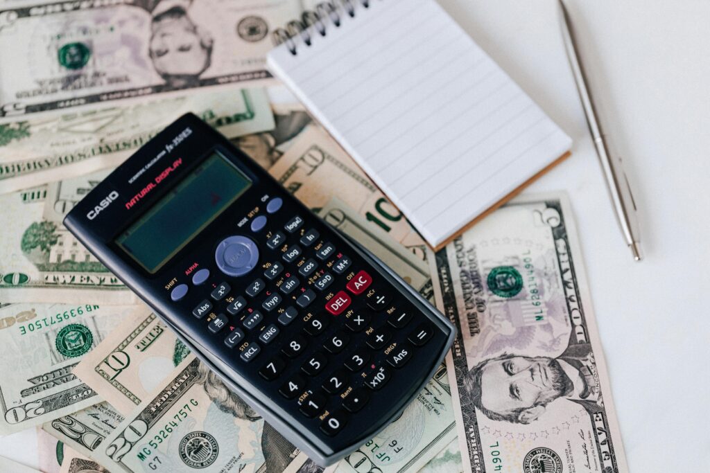 A calculator, symbolizing insurance insights, sits on top of a pile of money.