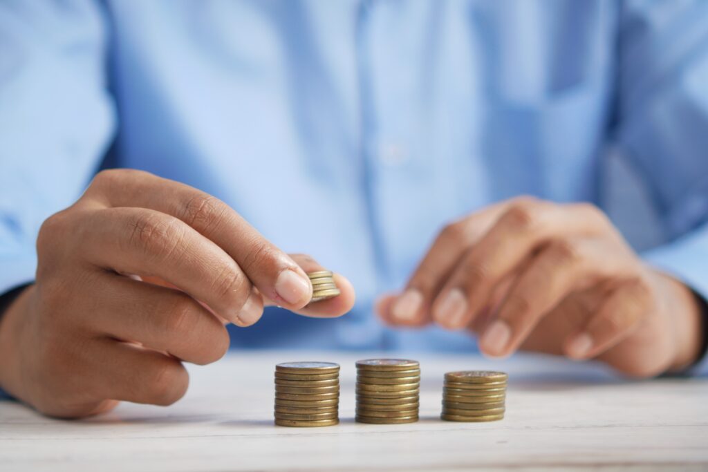 A man involved in a car crash is putting coins into a stack on a table during the insurance claims process.