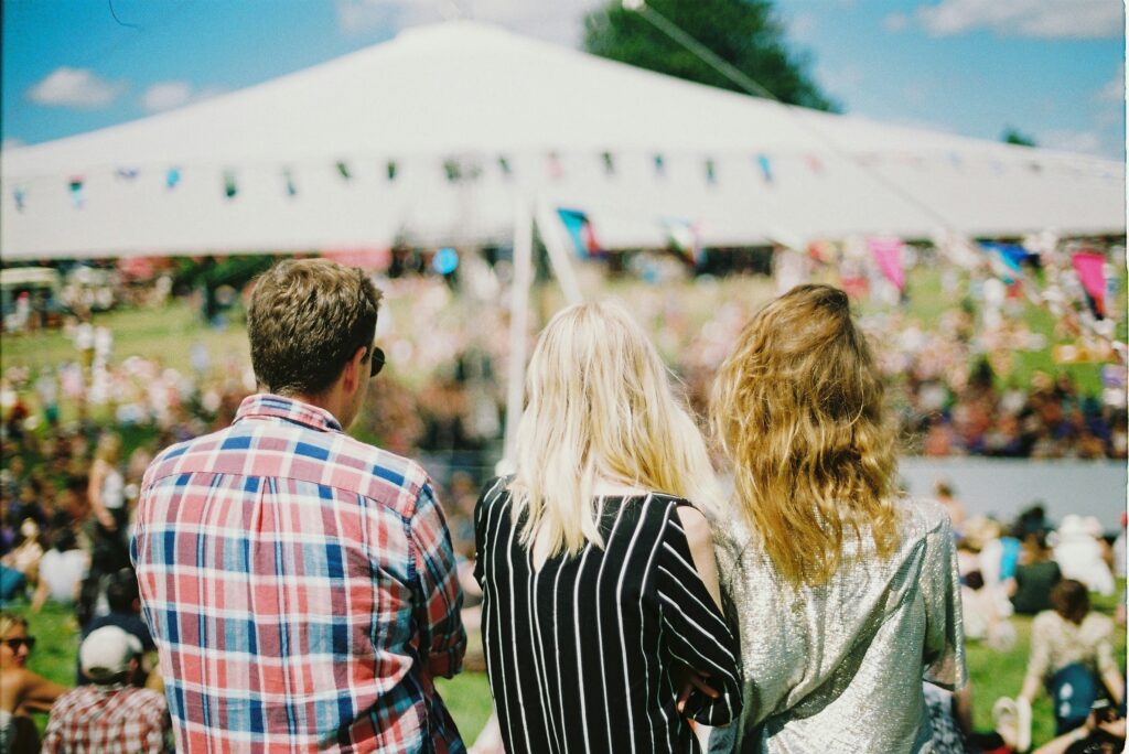 A group of people standing in front of a music festival tent at Isle of Wight Festivals.