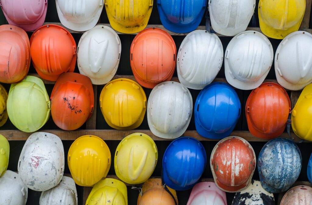 Many businesses take steps to ensure lone worker safety, such as providing hard hats lined up on a wall for protection.