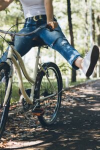 A woman is enjoying a fun bike ride in the park.