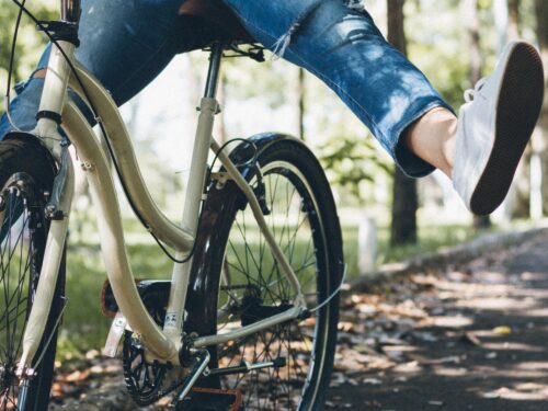 A woman is enjoying a fun bike ride in the park.