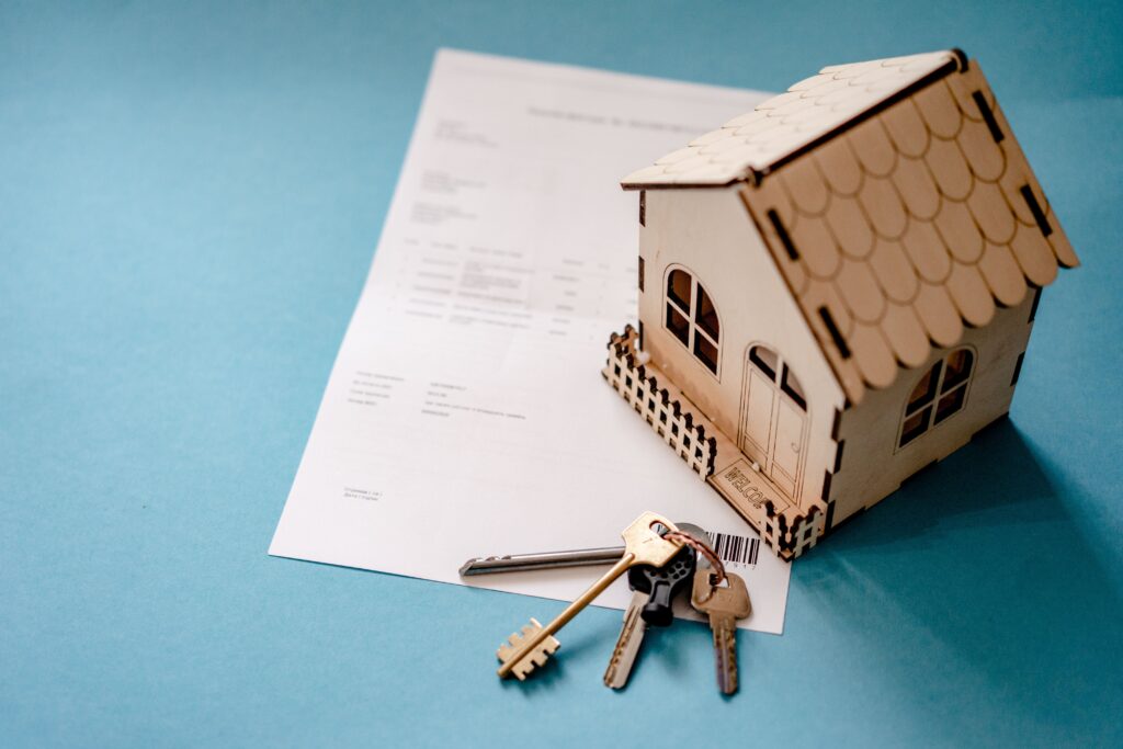 A Legit house model on top of a paper with keys.