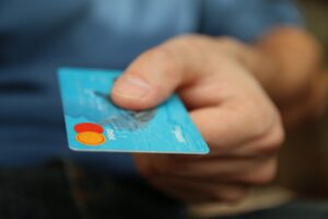 A person holding a credit card, seeking useful financial tips for paying off debts.