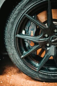 A close-up of a black car wheel showcasing the importance of regular tyre care.