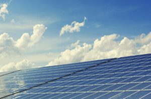 Solar panels against a backdrop of a clear blue sky with cumulus clouds, showcasing common solar panel problems.