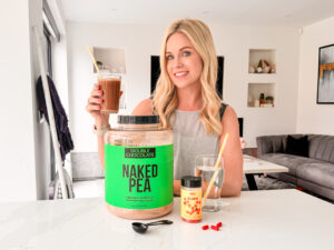 A woman holding a jar of pea protein.