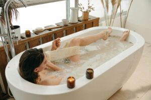 A person relaxing in a bathtub surrounded by a peaceful, plant-decorated setting knows how to keep themselves smelling fresh.