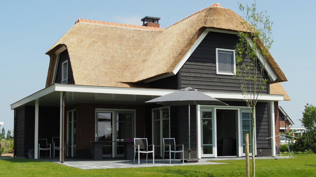 A black house with a thatched roof.