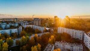 Aerial view of a residential area at sunrise with sunlight peeking between buildings, capturing the evolution of the UK real estate sector.